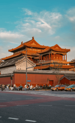 Traditional Chinese palace architecture with orange roof tiles against a blue sky in Beijing.