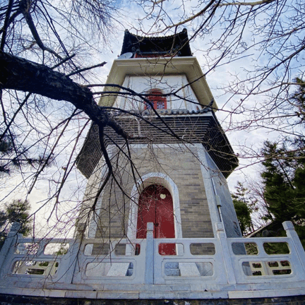 Stone entrance gate and wooded hillside at the north gate of Qianling Mountain scenic area in Beijing.