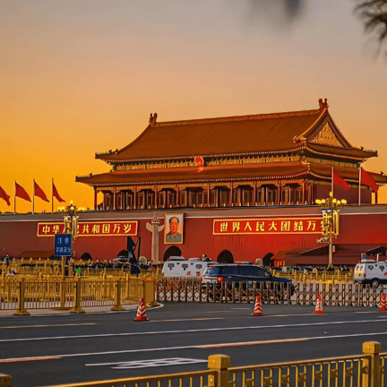 Tiananmen Gate in Beijing at sunset featuring the portrait of Mao Zedong and Chinese architecture.