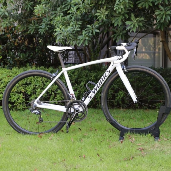 White Specialized S-Works Tarmac carbon fiber road bike parked on a green lawn.