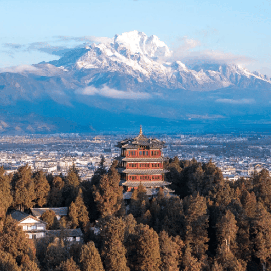 Ancient Chinese pagoda in Lijiang Old Town with the snow-capped Jade Dragon Snow Mountain in the background.