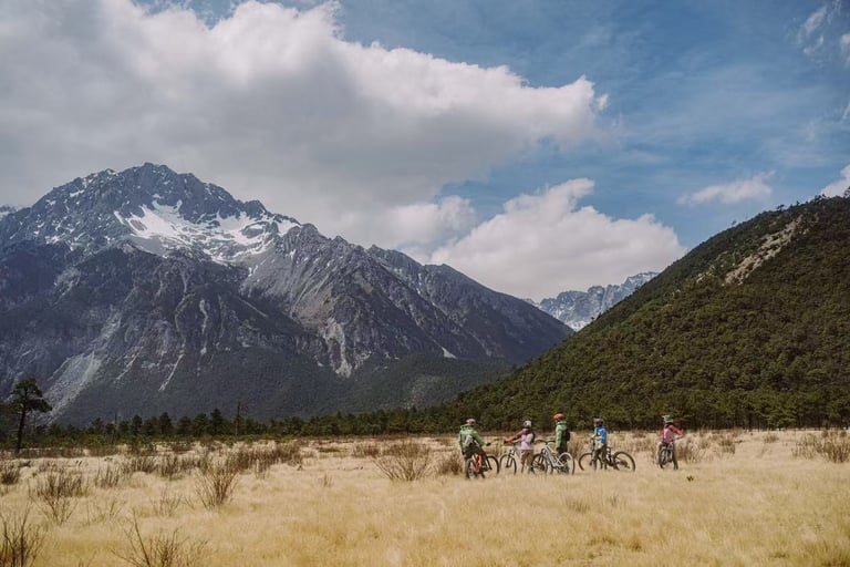 Riders on the Ganheba dry riverbed beneath Jade Dragon Snow Mountain