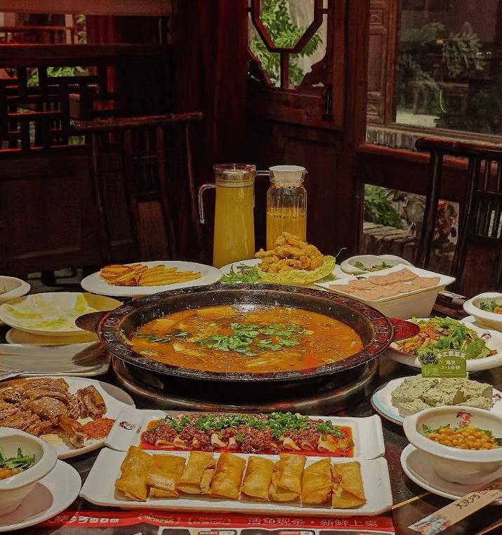 Authentic Chinese hot pot dinner with spring rolls, spicy meat, and dipping sauces in a traditional restaurant.