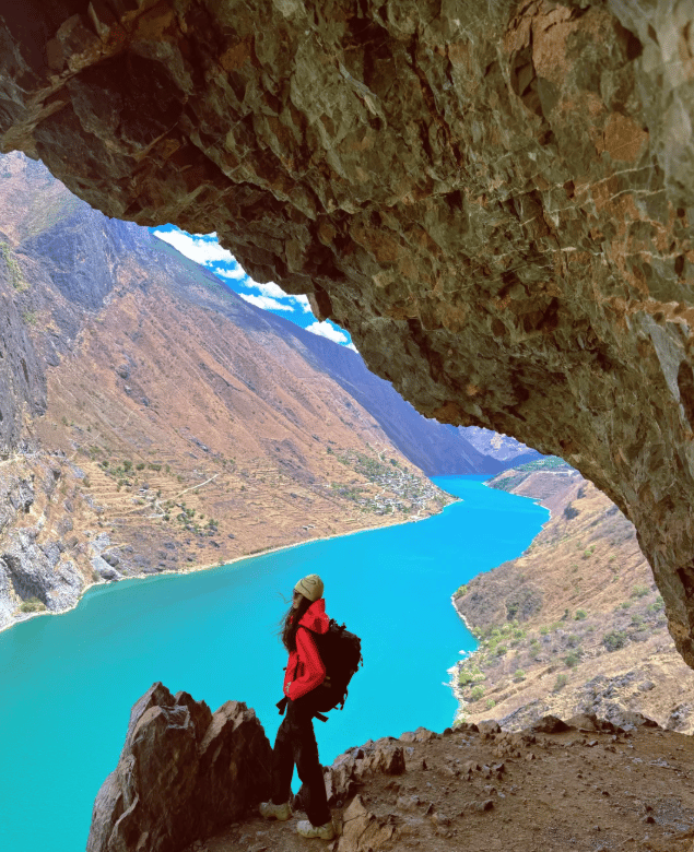Hikers on the high trail of the Jinsha River Canyon with snow mountains in the distance.